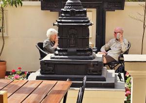 an older man and woman sitting at a table with a statue at Central Courtyard Thamel - Kathmandu's Best Kept Secret in Kathmandu
