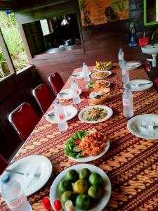 a long table with plates of food on it at Orangutan Borneo Tour Tanjung Puting in Pangkalan Bun