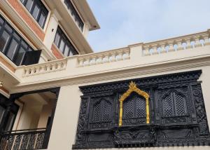 ein kunstvoll verzierter schmiedeeiserner Balkon an der Seite eines Gebäudes in der Unterkunft Central Courtyard Thamel - Heritage Hötel & Artisan Café in Kathmandu