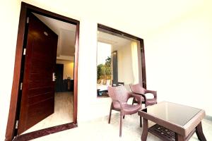 ein Raum mit zwei Stühlen und einem Tisch und einer Tür in der Unterkunft DL Resort Dhikuli Jim Corbett in Garjia