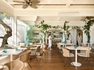 a restaurant with tables and chairs and people in the background at Raes on Wategos in Byron Bay