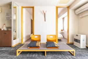 een kamer met 2 stoelen en een tafel bij Cozy Stay Sapporo Central Nakajima in Toyohira +212 foto's