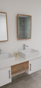 een badkamer met twee wastafels en een spiegel bij Les Vues de Monte Carlos in Tamarin