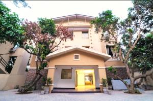 ein Gebäude mit einer gelben Tür und einigen Bäumen in der Unterkunft DL Resort Dhikuli Jim Corbett in Garjia