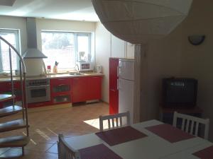 a kitchen with a table and a kitchen with a refrigerator at Auli Beach Area Holiday Home in Pärnu