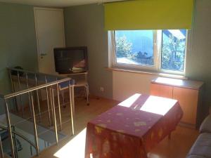 a living room with a table and a television at Auli Beach Area Holiday Home in Pärnu