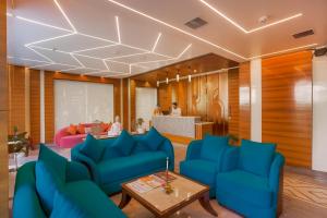 アムリトサルにあるHotel SG Continental Amritsar !! Prime Location ! Parking ! Open terraceの青いソファとテーブルが備わるロビー