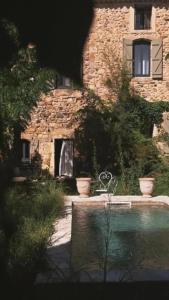 a stone building with a bench in front of it at La Potentille in Lieuran-Cabrières +39 photos