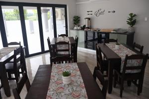 a dining room with tables and chairs and a kitchen at GuestHouseVine&Stone in Clarens