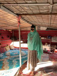 een vrouw die voor een zwembad staat bij Al Salam Desert Camp Oman in Al Qābil
