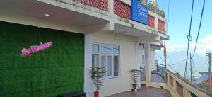 a building with a green wall with a sign on it at Sri Vrindavan Guest House Pure Veg in Darjeeling