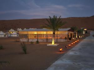 een gebouw met lichten in de woestijn 's nachts bij Al Salam Desert Camp Oman in Al Qābil