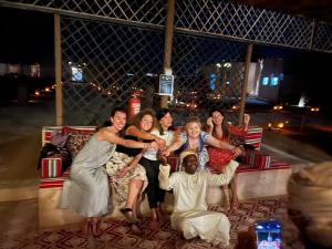 een groep mensen die poseren voor een foto op een bank bij Al Salam Desert Camp Oman in Al Qābil +77 foto's