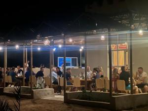 een groep mensen die 's nachts aan tafels zitten bij Al Salam Desert Camp Oman in Al Qābil