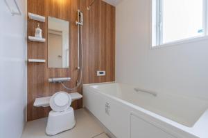 a bathroom with a tub and a toilet and a sink at Villa Katarima 西軽井沢 in Miyota +33 photos