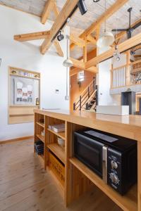 a kitchen with wooden cabinets and a counter with a microwave at Villa Katarima 西軽井沢 in Miyota