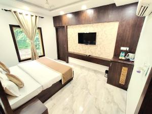 ein Schlafzimmer mit einem Bett und einem Fernseher in der Unterkunft DL Resort Dhikuli Jim Corbett in Garjia
