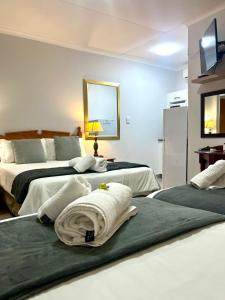 a bedroom with two beds with towels on them at Lily Guesthouse in Bloemfontein
