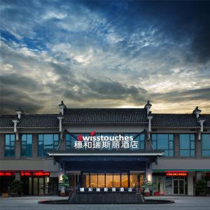 a building with a sign on the front of it at Swisstouches Guangzhou Hotel Residences in Guangzhou