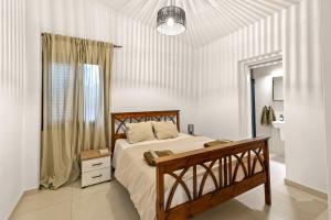 a bedroom with a bed with a wooden frame at Zeus Holiday Home in Pissouri +10 photos