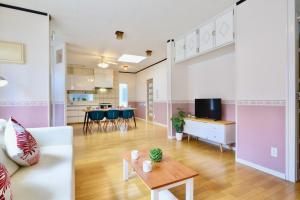 a living room with a couch and a table at 海徒歩1分アメリカンビレッジまで7分周辺には飲食店多数の北谷エリアSunabeNest in Chatan