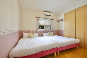 a bedroom with a large bed in a room at 海徒歩1分アメリカンビレッジまで7分周辺には飲食店多数の北谷エリアSunabeNest in Chatan