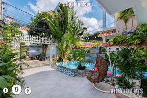 a resort with a pool and a chair and plants at Biệt thự Bãi Sau Võ Thị Sáu khu Á Châu in Vung Tau