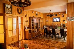 a dining room and kitchen with a table and chairs at Casa dintre Pini Agapia in Agapia