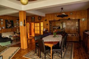 a dining room and kitchen with a table and chairs at Casa dintre Pini Agapia in Agapia
