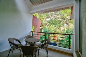 ein Balkon mit Tisch und Stühlen und einem Fenster in der Unterkunft LUXURY 3BHk VILLA WITH PRIVATE POOL NEAR CANDOLIM in Goa