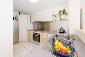 Una cocina con un bol de fruta en el fregadero. en CBD Apartment with River Views Pool & Parking in Townsville, en Townsville