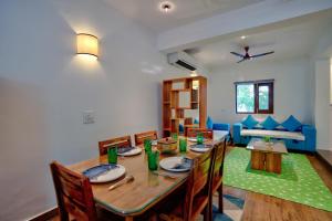 ein Esszimmer mit einem Holztisch und Stühlen in der Unterkunft LUXURY 3BHk VILLA WITH PRIVATE POOL NEAR CANDOLIM in Goa