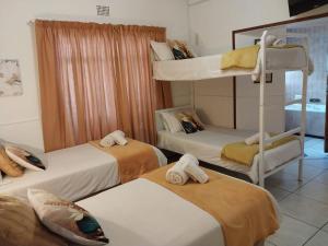a room with three bunk beds with towels at Lily Guesthouse in Bloemfontein