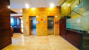 a hallway with two elevators in a building at HOTEL GARNET in Durg