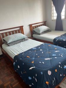 two twin beds in a bedroom with a comforter with fish at Homestay Vista3A at Vista Seri Putra in Kajang +20 photos