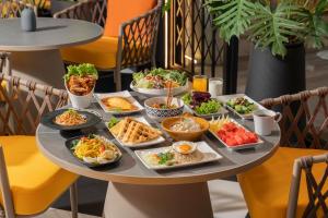 a tray of food on a table with plates of food at Hotel Bangkokian in Bangkok