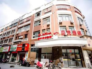 a pink building with red chairs on top of it at Shell Shanghai Songjiang District Xinqiao Town Xinqiao Hotel in Chunshen