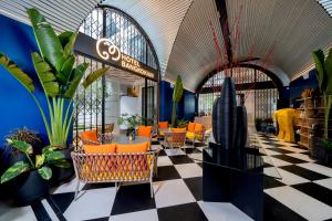 a lobby with orange chairs and potted plants at Hotel Bangkokian in Bangkok