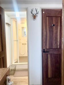 a door with a deer head hanging on a wall at Kumano Kodo Pilgrim's Rest Guesthouse Oto Nachikatsuura in Nachikatsuura +15 photos