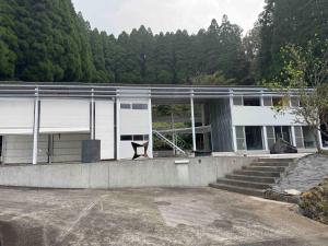 a large white building with trees in the background at OGUNI S HOUSE 2F Designed by Toyo Ito in Oguni