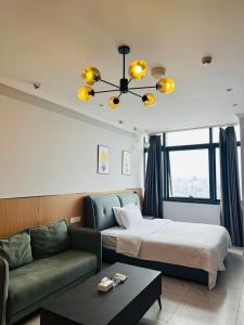 a hotel room with a bed and a couch at Chongqing Justom Family Serviced Apartments 4 in Chongqing