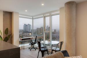 una sala da pranzo con tavolo, sedie e finestre di Corporate Stays The Wedge Studio a Victoria