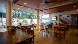 a restaurant with tables and chairs and a large window at Cheers Social Apartment & Hotel BKK1 in Phnom Penh