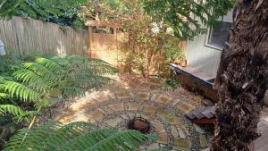 a garden with a spiral staircase in front of a fence at Ferntree Hollow - private, peaceful, walk to town in Maleny