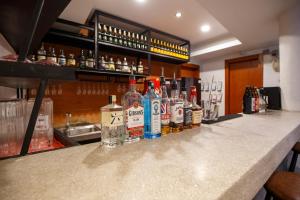 a bar with bottles of alcohol sitting on a counter at Cheers Social Apartment & Hotel BKK1 in Phnom Penh