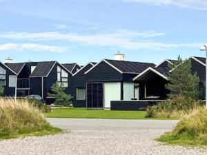 a row of black houses with a driveway at 6 person holiday home in Hadsund in Hadsund