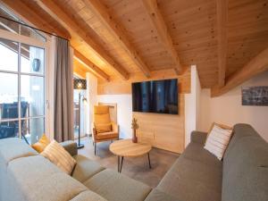a living room with a couch and a tv at Luxury penthouse with Balcony, Ski Storage, Carport, Lift in Brixen im Thale