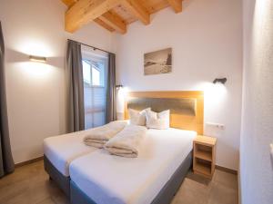 a bedroom with a white bed with towels on it at Luxury penthouse with Balcony, Ski Storage, Carport, Lift in Brixen im Thale