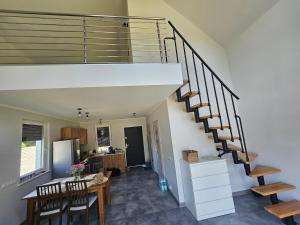a staircase in a living room with a table and a kitchen at Leśny Zakątek Świączyń  +7 photos