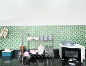 een keuken met een magnetron en een plank met borden bij Per La Villa Khao Lak in Khao Lak +30 foto's